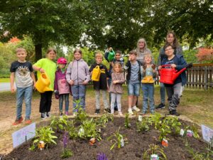 Kinder und Gemeinderat bepflanzen ehemaligen Spielplatz