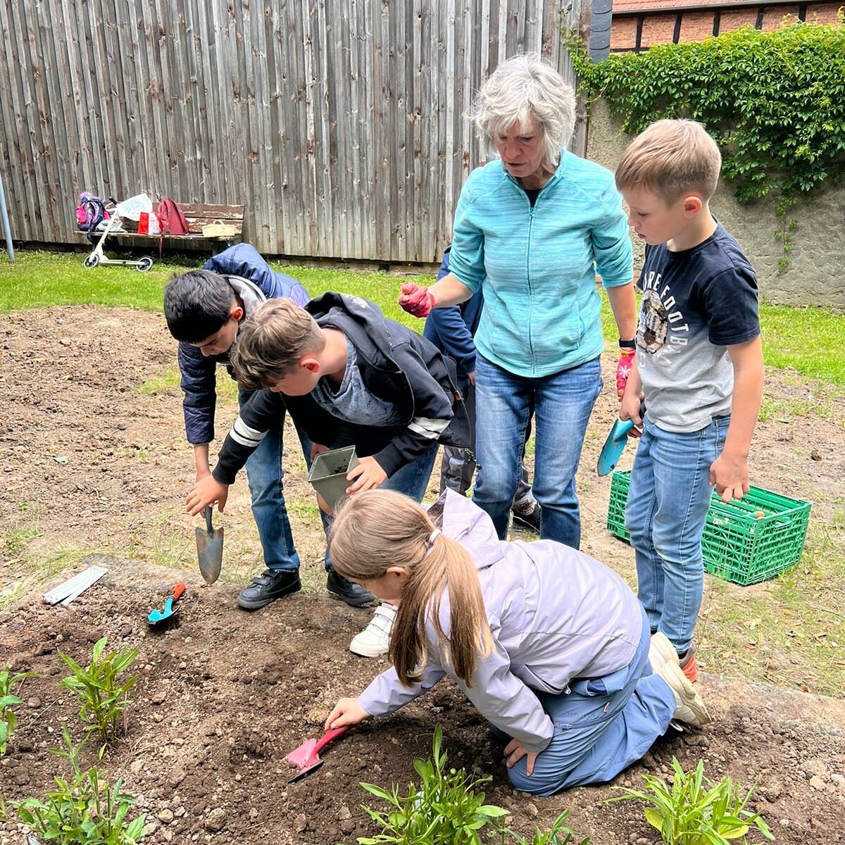 Die Kinder des Horts bepflanzen ein Bumenbeet auf dem ehemaligen Spielplatz